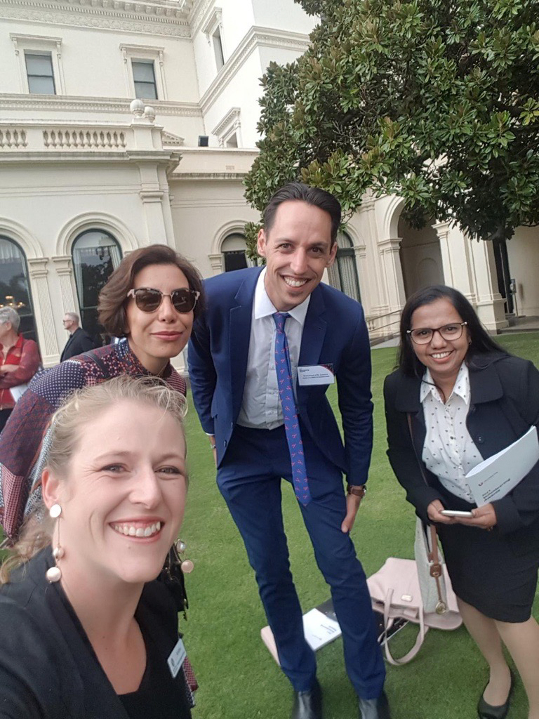 Our Digital Literacy team posing for a photo. There are four people standing on the lawn in front of a grand building