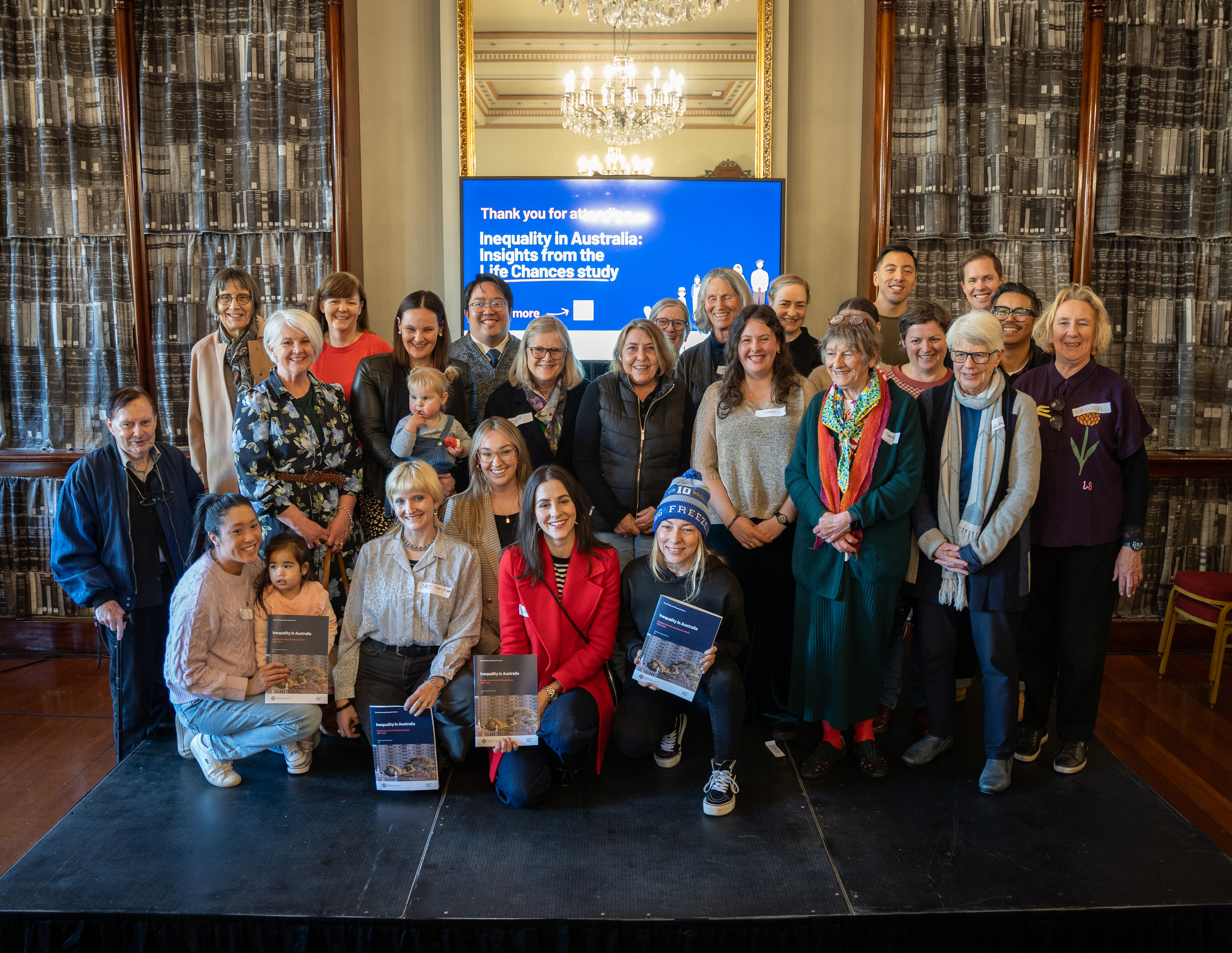 A group of people in the Fitzroy Reading room facing the camera and smiling