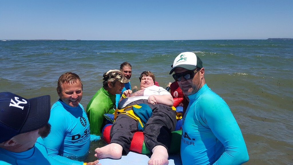 Cheryl being helped to go surfing