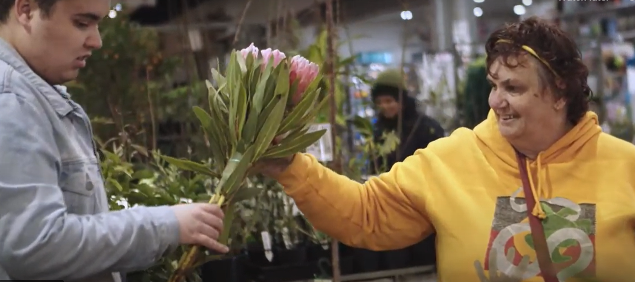 A woman buys flowers at a shop