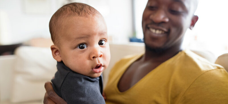 Baby indoors playing with father