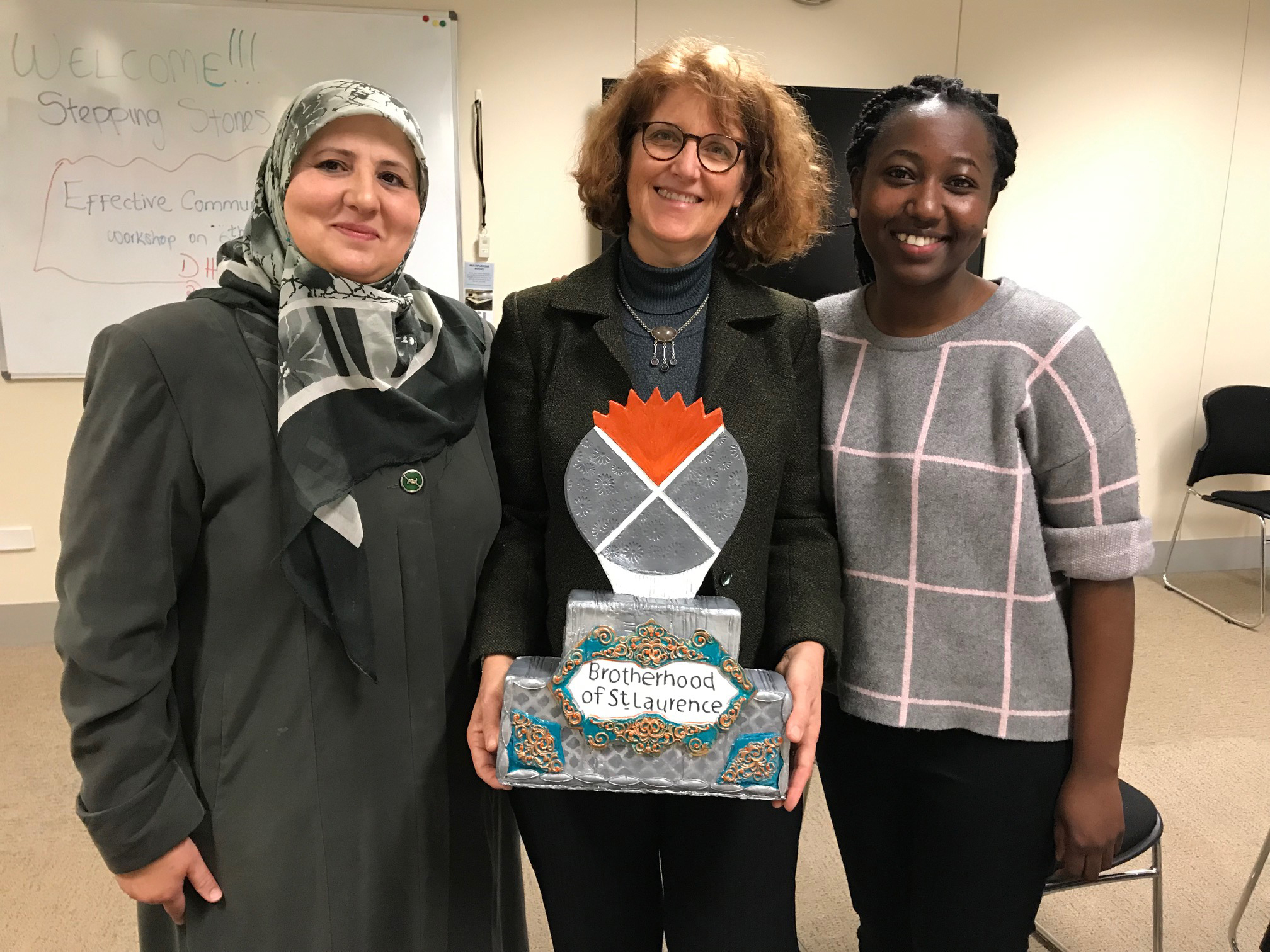 Linet and Meredith from our Multicultural Communities team with Ahlam who started her own business, Cookies by Dreams, through our Stepping Stones to Small business program, and made this incredible, edible trophy for the team.