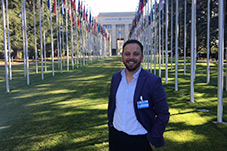 Joseph Youhana in the UN grounds with flagpoles behind him