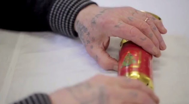 Older tattooed hands on Christmas cracker