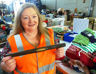 Volunteer holds up stick for inspection