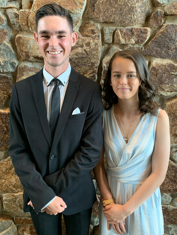 Two smiling young students dressed formally