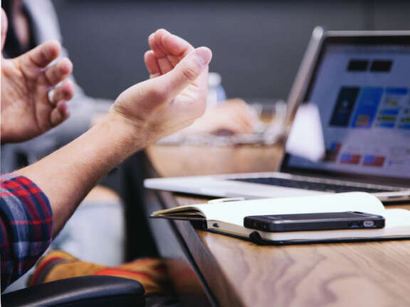 Hands with laptop, phone and notepad