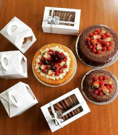Three cakes, boxed biscuits and cupcakes
