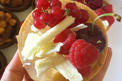 Top view of a small Lilly cake covered in berries and white chocolate
